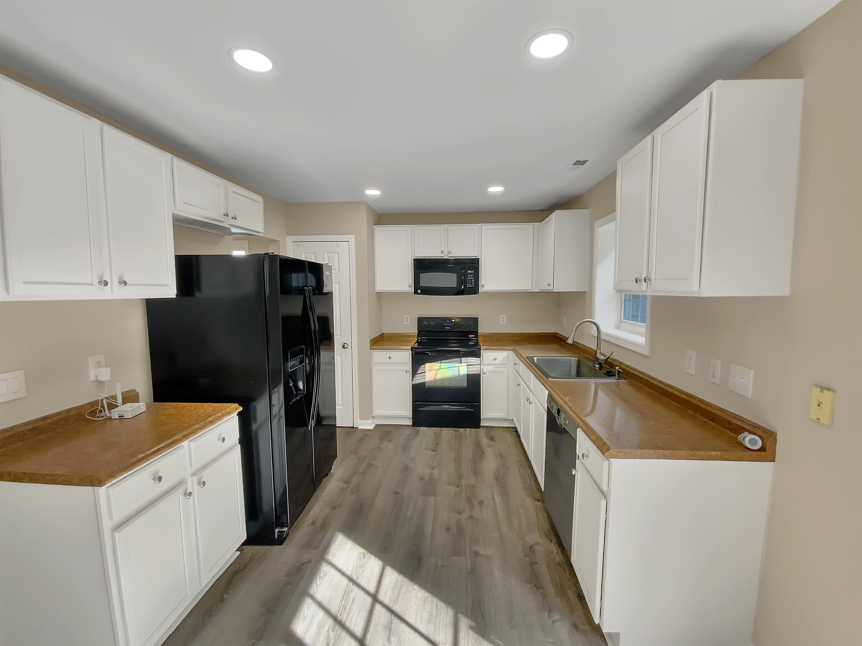 113 Brierridge Drive Apex, NC 27502 - Photo 8 of 20 a kitchen with granite countertop a refrigerator a sink a stove top oven and white cabinets