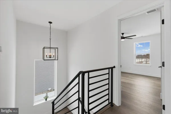 a view of a hallway with stairs and a window