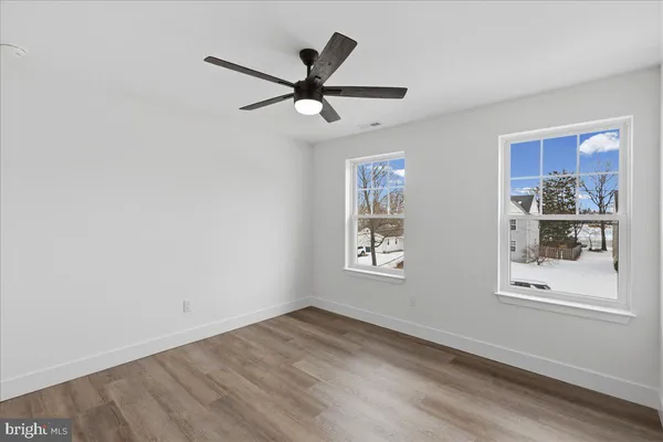 a view of a big room with wooden floor and windows
