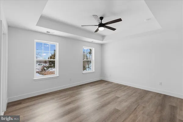 a view of a big room with wooden floor and windows