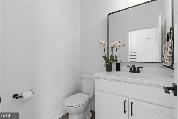 a bathroom with a sink vanity mirror and toilet