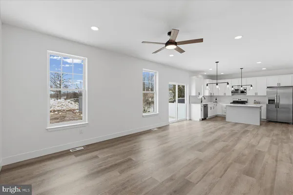a view of an empty room with window and wooden floor