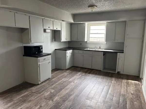 a kitchen with granite countertop a sink cabinets and stainless steel appliances