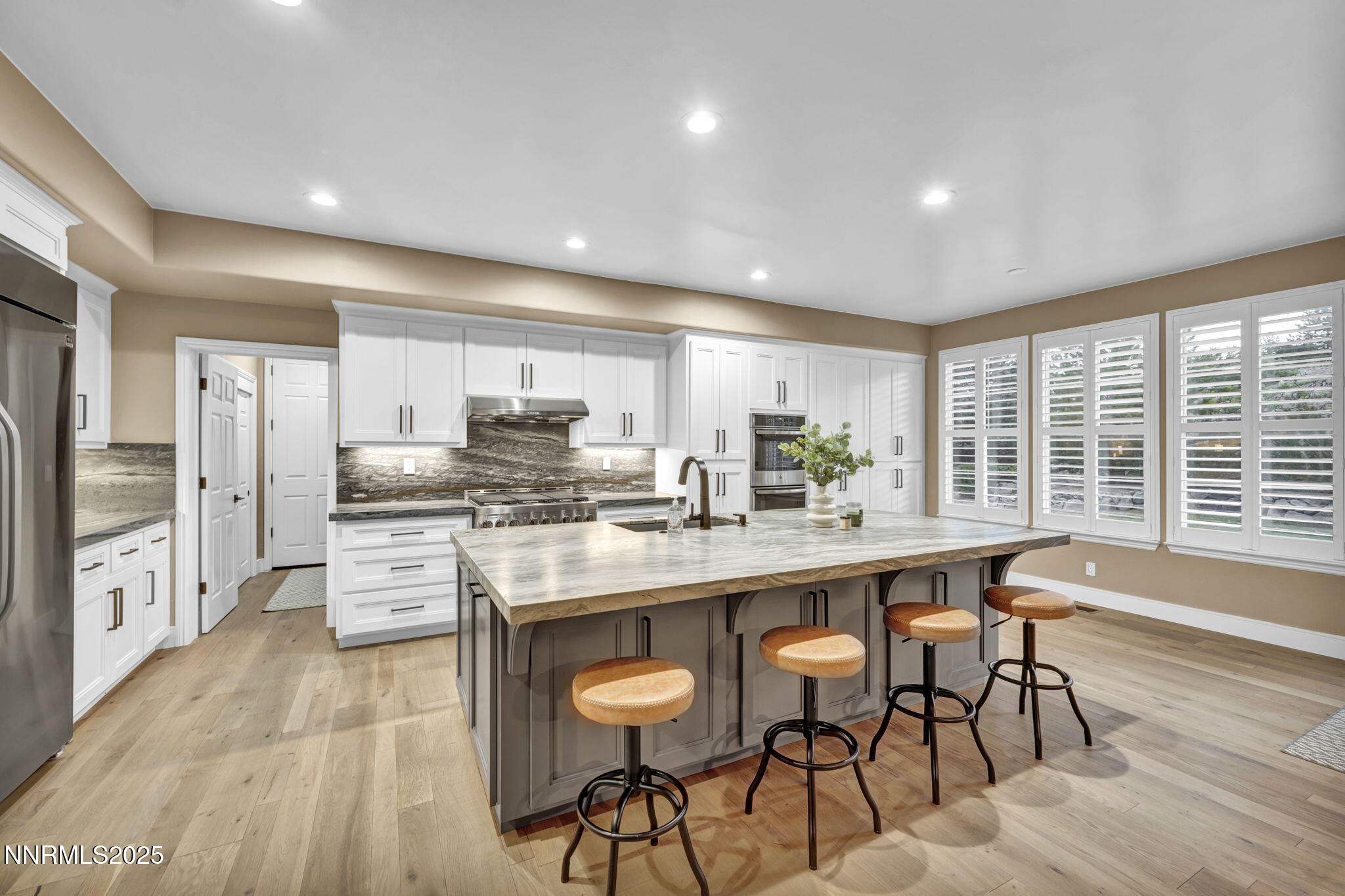 2965 Roundrock Court Reno, NV 89511 - Photo 4 of 119 a kitchen with stainless steel appliances kitchen island granite countertop a stove a refrigerator a sink and white cabinets with wooden floor