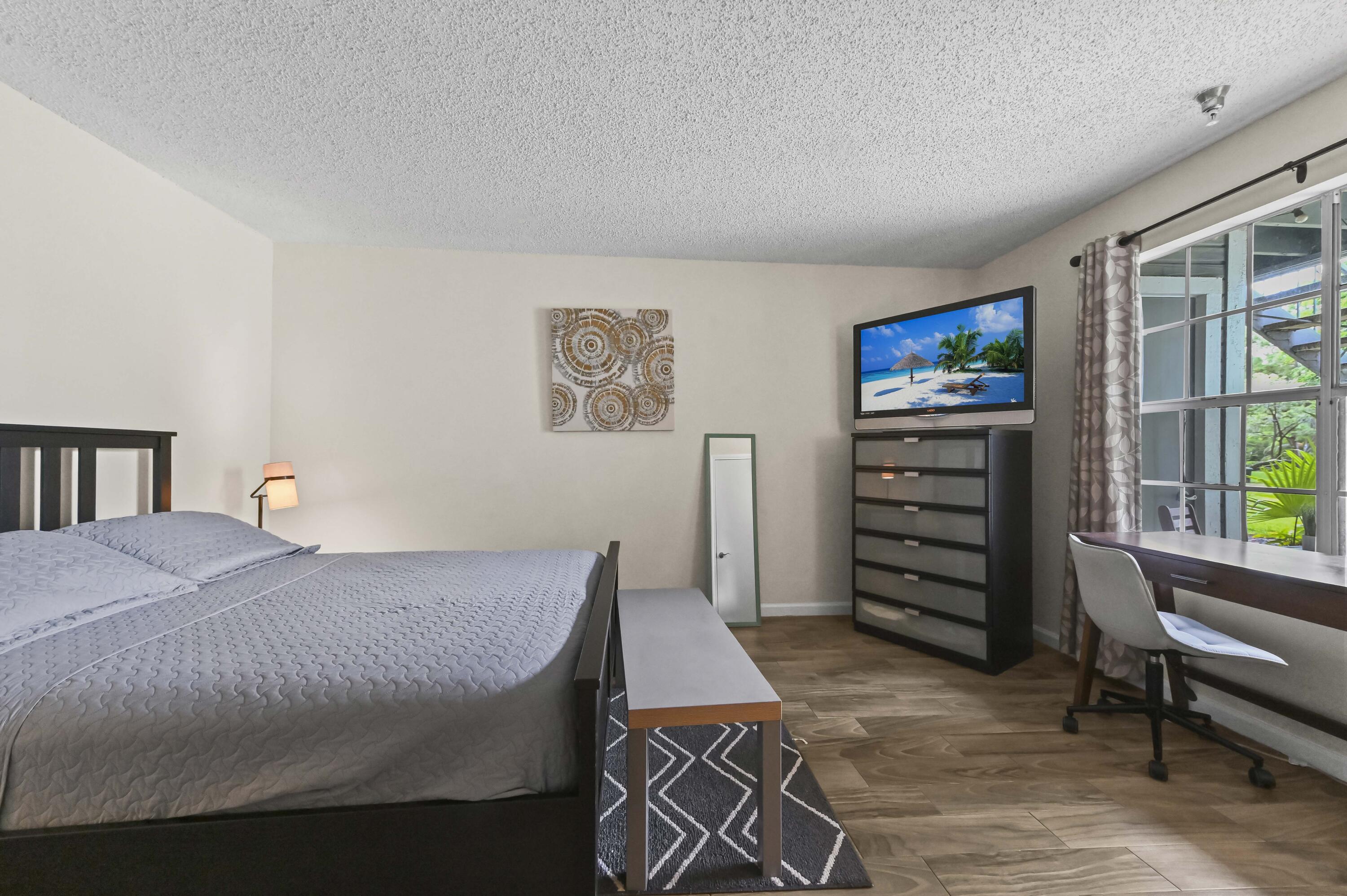 1205 Crystal Way, Unit K Delray Beach, FL 33444 - Photo 15 of 25 a bedroom with a bed and a bookshelf