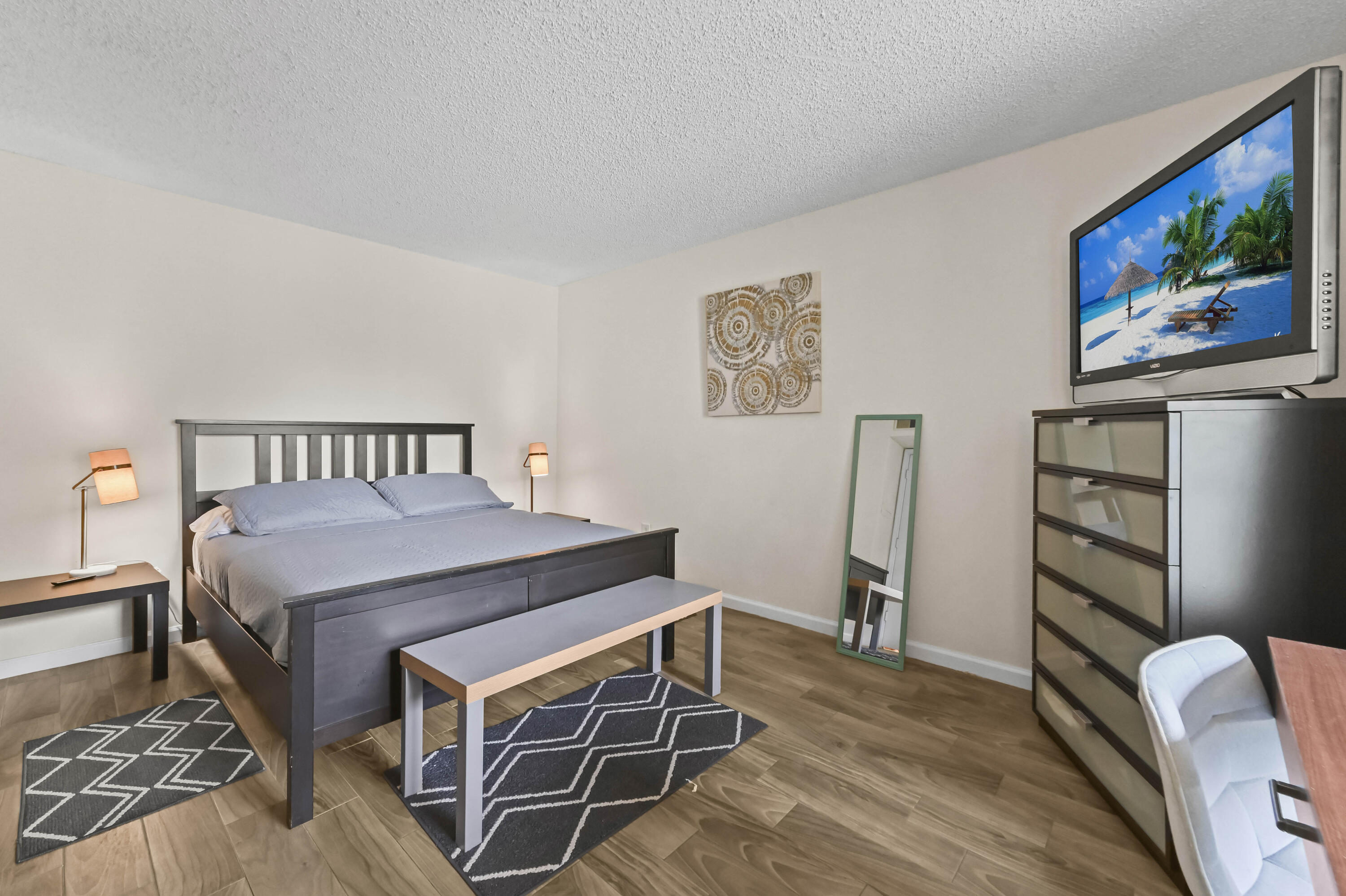 1205 Crystal Way, Unit K Delray Beach, FL 33444 - Photo 16 of 25 a bed sitting in a bedroom next to a tv