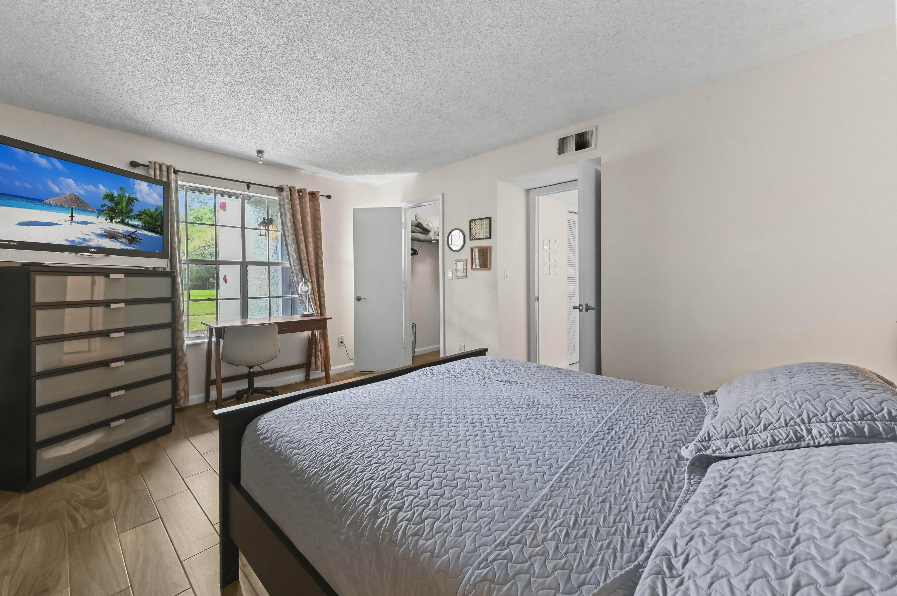 1205 Crystal Way, Unit K Delray Beach, FL 33444 - Photo 17 of 25 a bedroom with a bed and a dresser