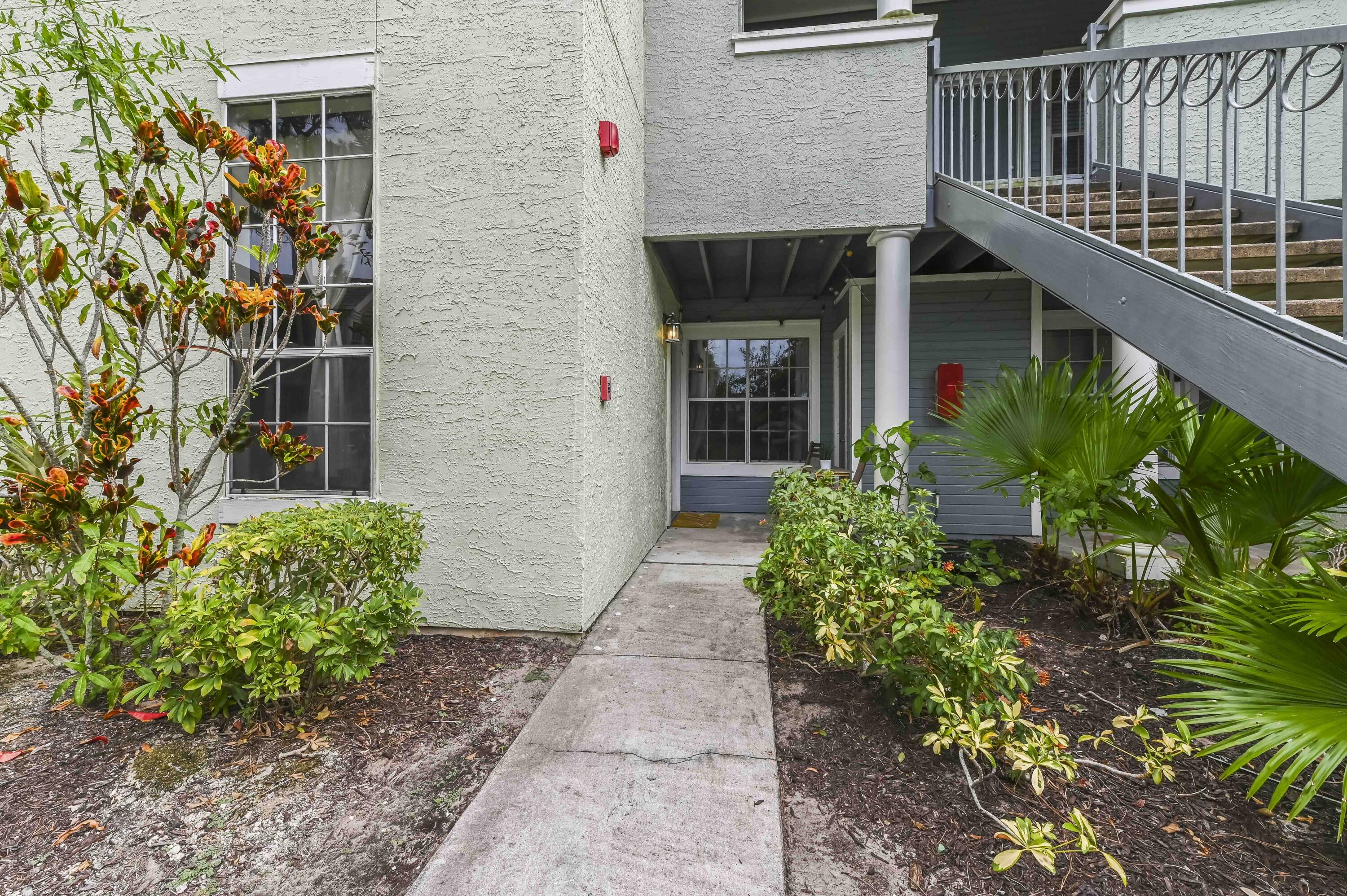 1205 Crystal Way, Unit K Delray Beach, FL 33444 - Photo 24 of 25 a house with potted plants in front of it