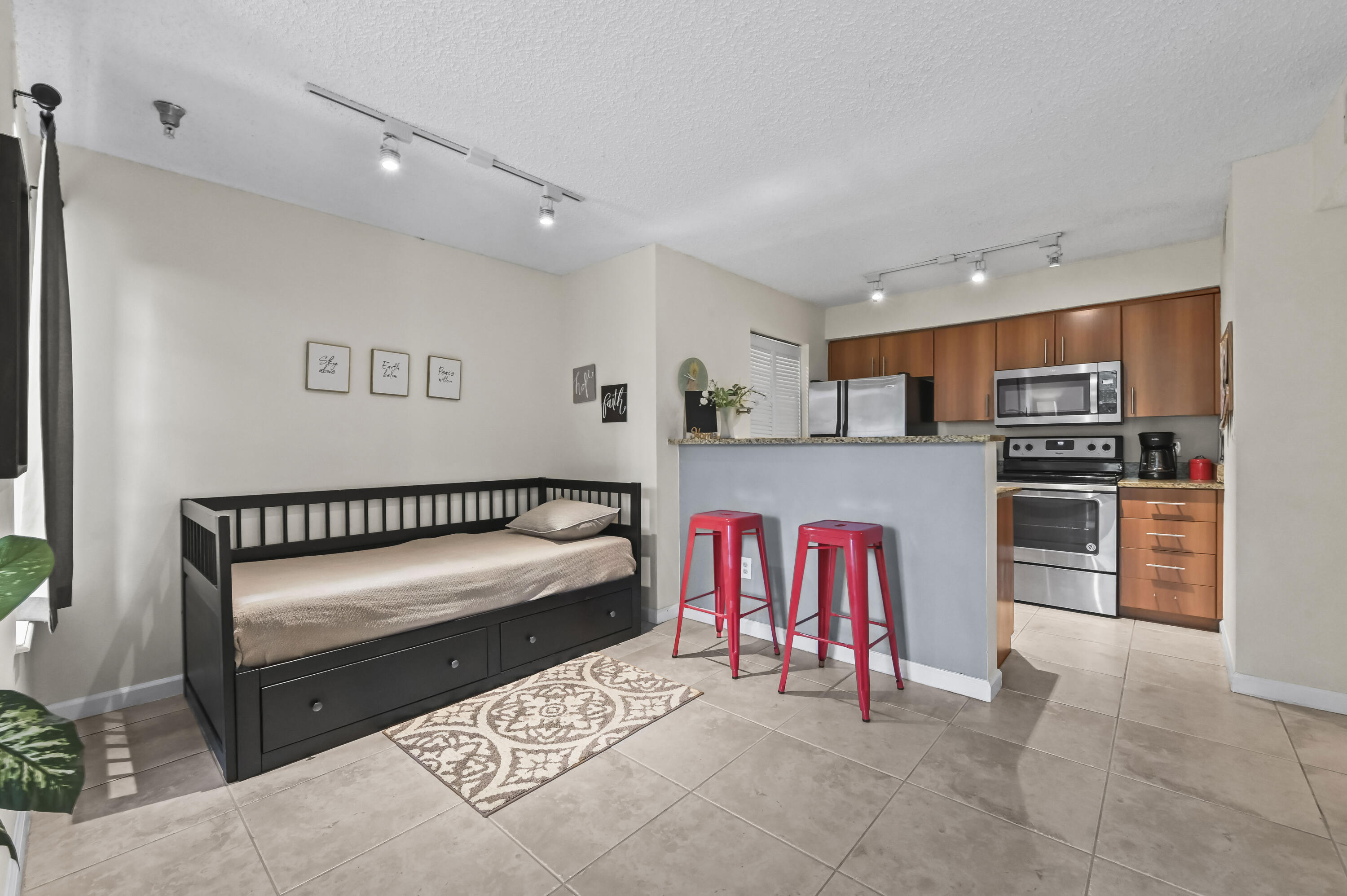 1205 Crystal Way, Unit K Delray Beach, FL 33444 - Photo 8 of 25 a kitchen with stainless steel appliances kitchen island granite countertop a refrigerator and a stove top oven