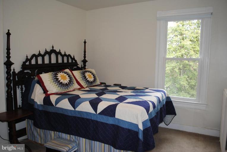 1403 Foxhall Road Northwest Washington, DC 20007 - Photo 15 of 22 a bedroom with a bed window and a table in it