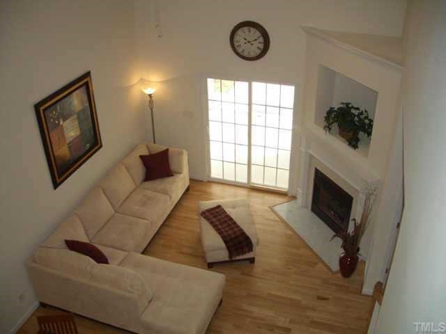 7306 Caversham Way Raleigh, NC 27617 - Photo 5 of 6 a living room with furniture a fireplace and a large window