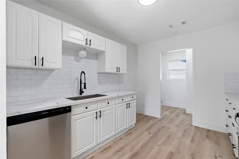 a kitchen with a sink cabinets and wooden floor