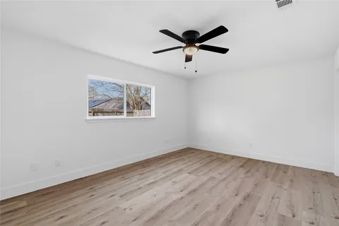 a view of a big room with wooden floor and windows