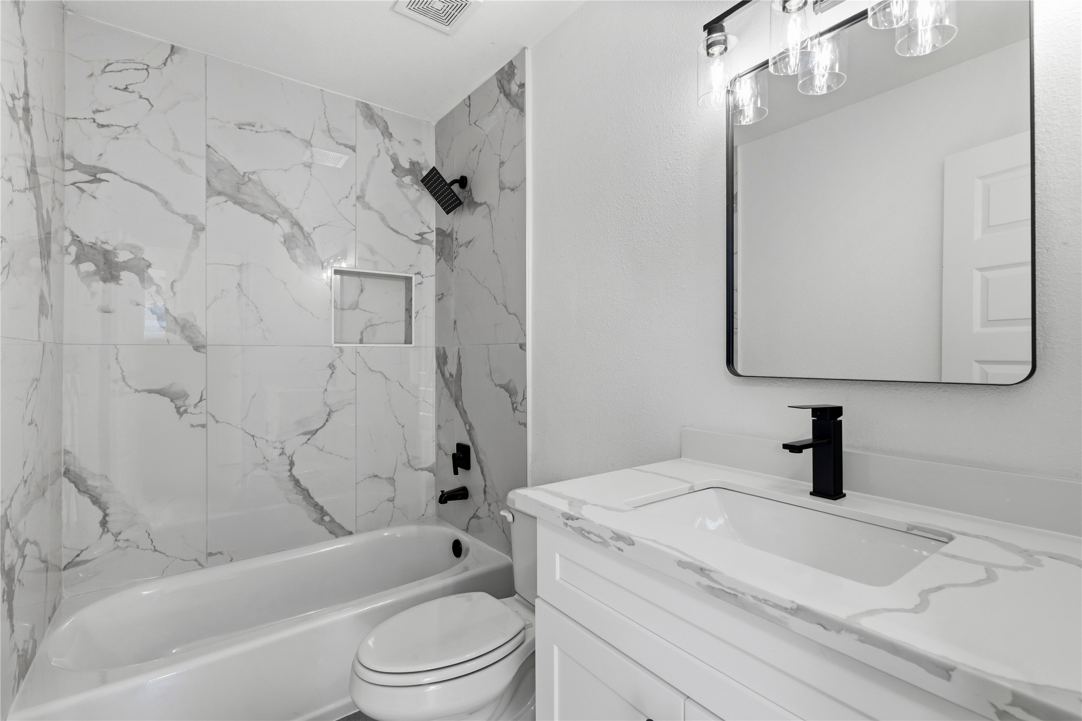 9809 Wren Court Conroe, TX 77385 - Photo 18 of 22 a bathroom with a toilet sink a mirror a vanity and bathtub