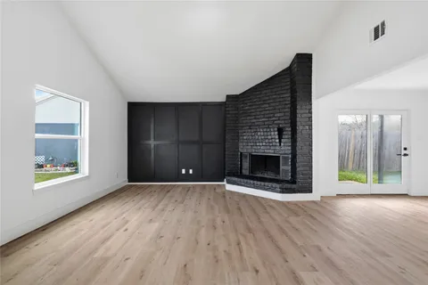 an empty room with windows and a fireplace