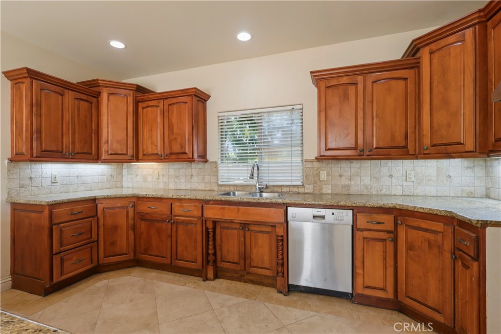 17100 Apple Street Bellflower, CA 90706 - Photo 12 of 38 a kitchen with stainless steel appliances granite countertop wooden cabinets a sink and dishwasher a oven with granite countertops