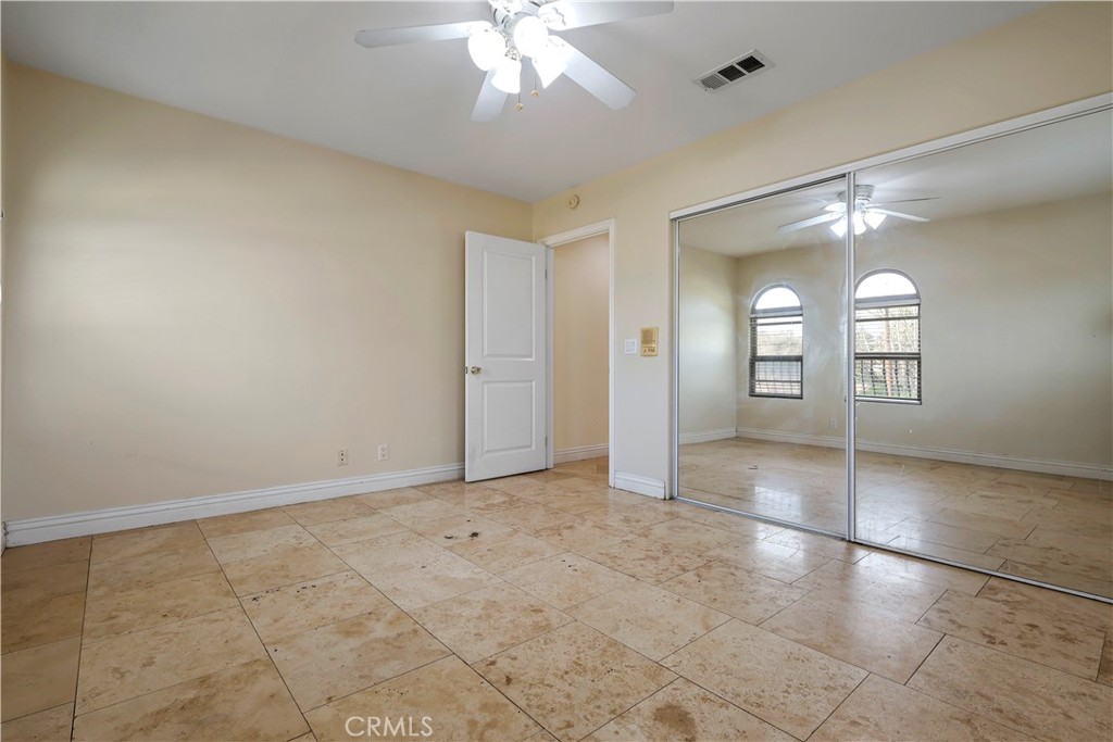17100 Apple Street Bellflower, CA 90706 - Photo 17 of 38 an empty room with a chandelier fan and windows