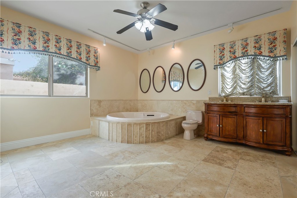 17100 Apple Street Bellflower, CA 90706 - Photo 32 of 38 a bathroom with a bathtub sink mirror vanity and toilet