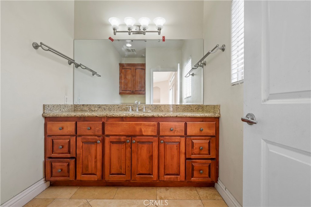 17100 Apple Street Bellflower, CA 90706 - Photo 34 of 38 a bathroom with a granite countertop sink and a mirror