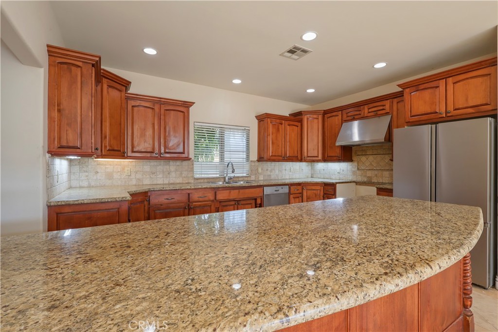 17100 Apple Street Bellflower, CA 90706 - Photo 10 of 38 a kitchen with stainless steel appliances granite countertop a sink stove and refrigerator