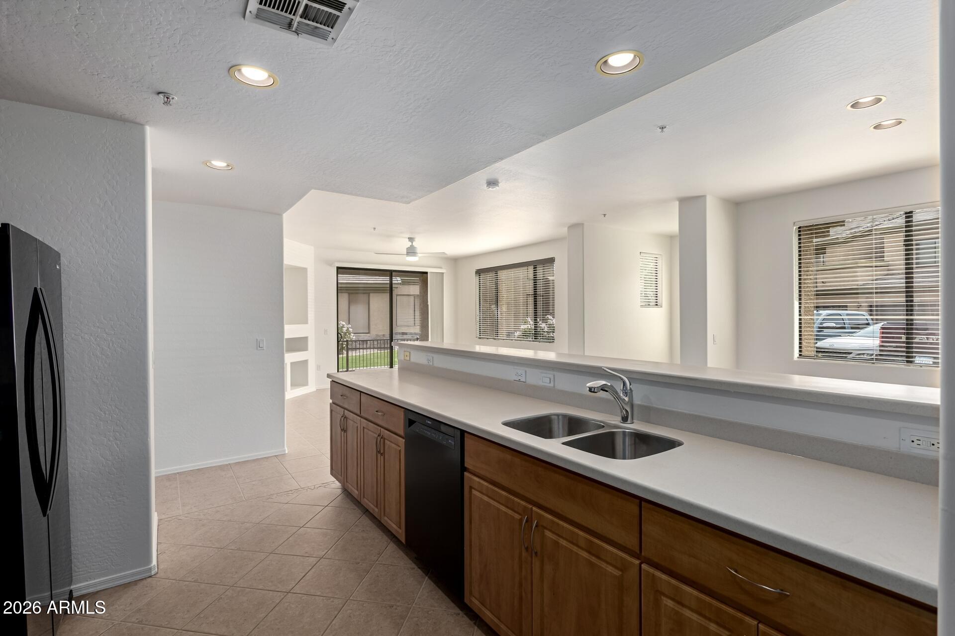 705 West Queen Creek Road, Unit 1167 Chandler, AZ 85248 - Photo 11 of 31 a kitchen with stainless steel appliances granite countertop a sink and a refrigerator