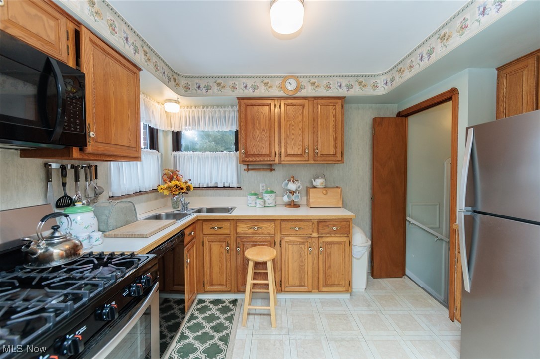 6192 Stanbury Road Parma, OH 44129 - Photo 24 of 49 Kitchen featuring black appliances, light flooring, light countertops, and brown cabinets