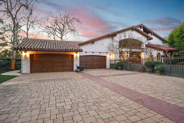 a view of a patio with table and chairs potted plants and large tree