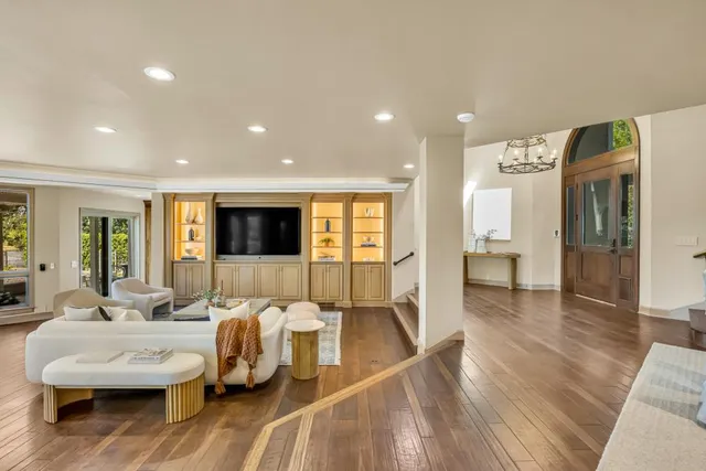 a room with lots of white furniture and a large window