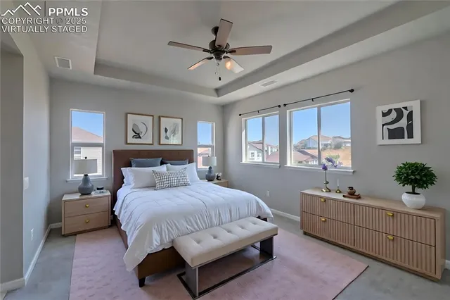 a bedroom with a large bed and a chandelier fan
