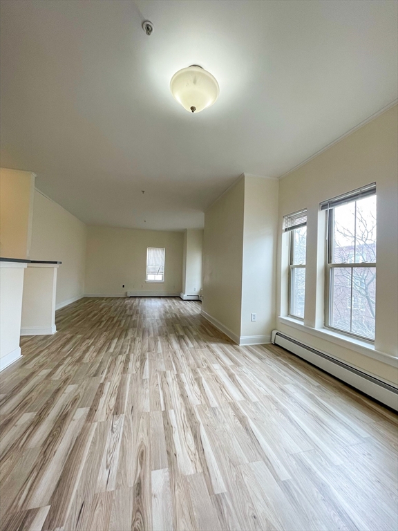 12 Humphreys Street, Unit 8 Boston, MA 02125 - Photo 4 of 7 a view of empty room with wooden floor and fan