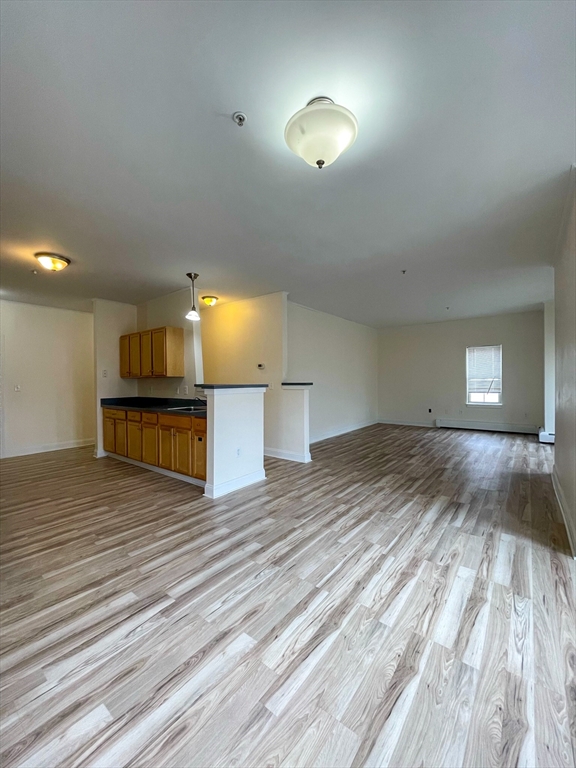 12 Humphreys Street, Unit 8 Boston, MA 02125 - Photo 5 of 7 a view of kitchen and empty room with wooden floor