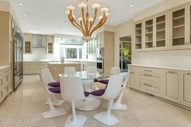 a dining room with furniture a chandelier and a flat screen tv
