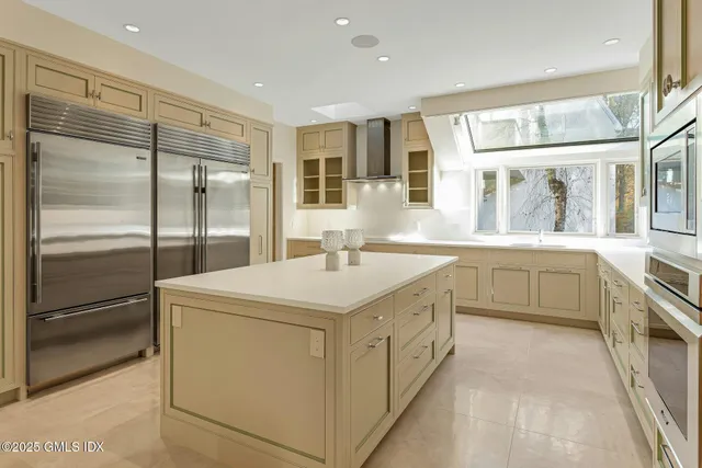 a living room with furniture a flat screen tv and floor to ceiling window
