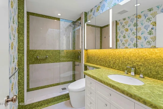 a bathroom with a granite countertop sink toilet and shower
