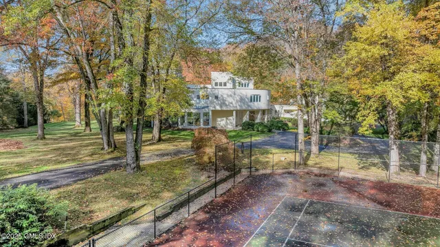 a aerial view of residential house with outdoor space and trees all around