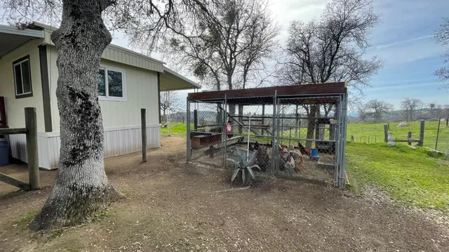 a view of a chair and table in backyard of the house