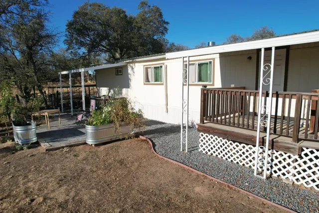 a white house with a big yard and large trees