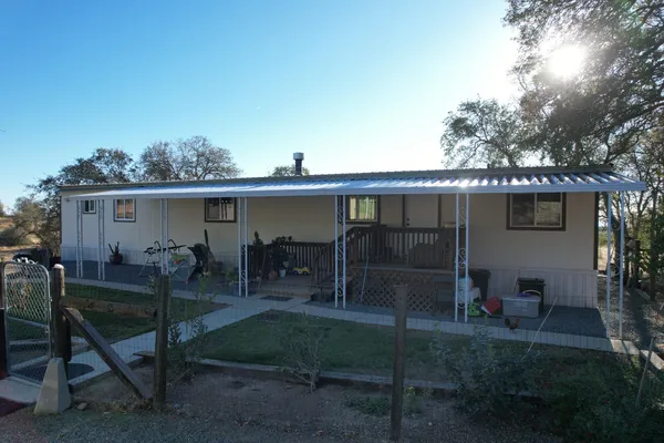 a view of house with yard and sitting area