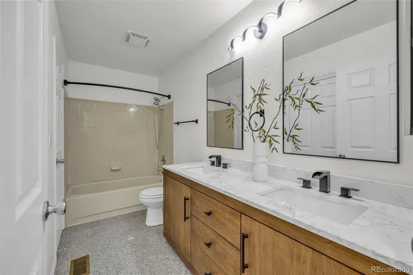 a bathroom with a granite countertop sink toilet and shower