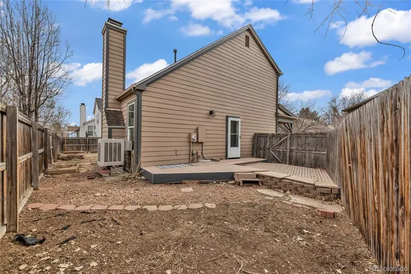 a view of a house with backyard and wooden fence