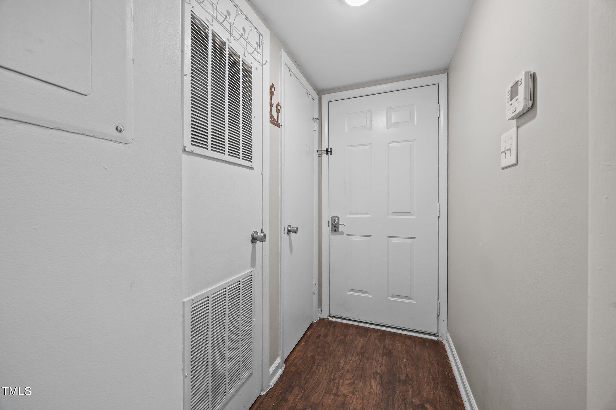 7020 Longstreet Drive, Unit A Raleigh, NC 27615 - Photo 4 of 27 a view of a hallway with wooden floor and a bathroom