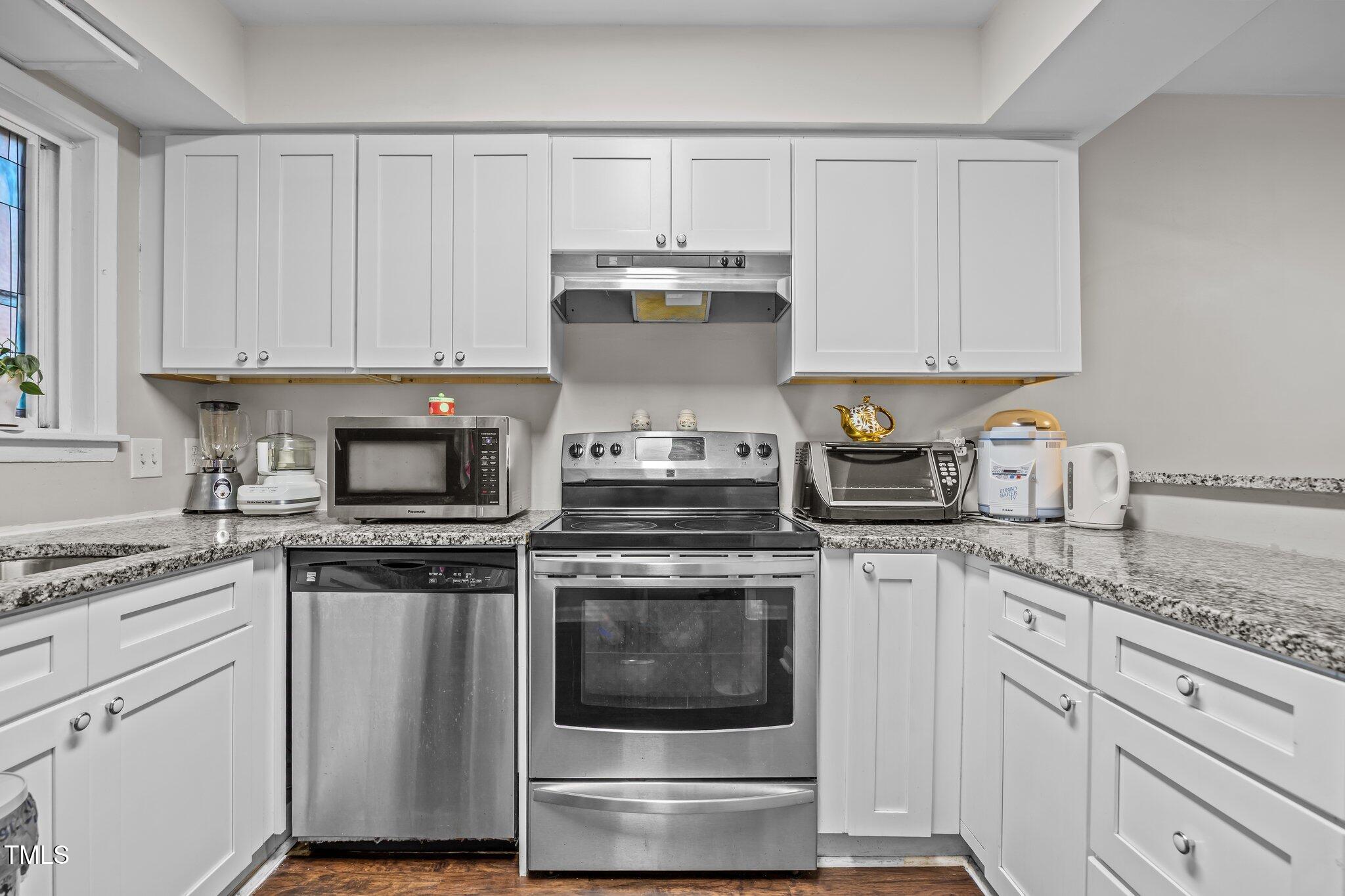 7020 Longstreet Drive, Unit A Raleigh, NC 27615 - Photo 6 of 27 a kitchen with granite countertop white cabinets and white appliances