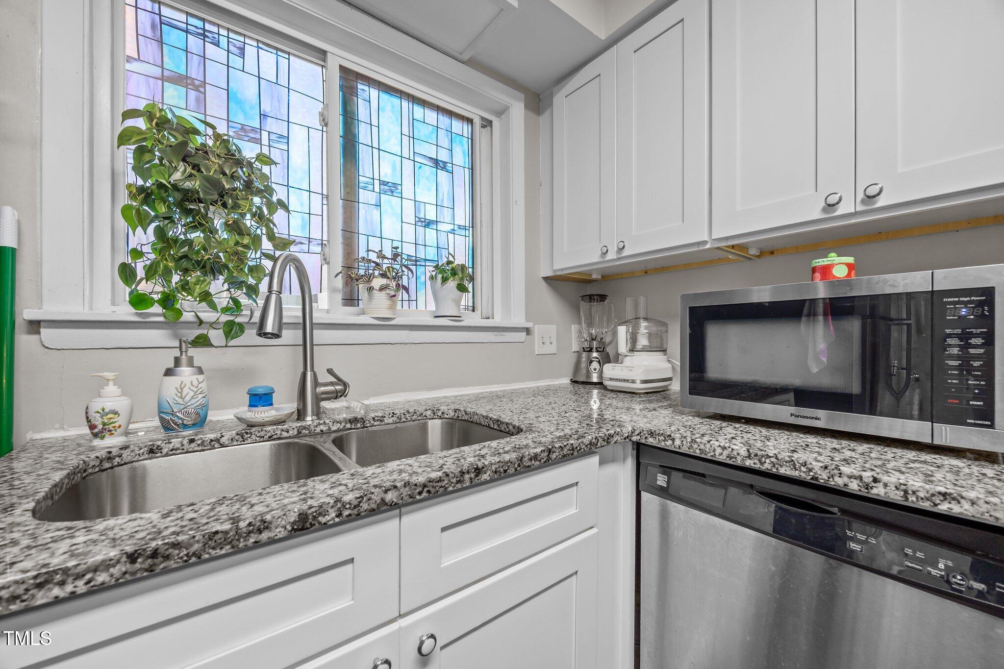 7020 Longstreet Drive, Unit A Raleigh, NC 27615 - Photo 8 of 27 a kitchen with granite countertop a sink a microwave and cabinets