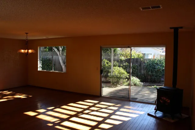 a view of a room with wooden floor and a floor to ceiling window