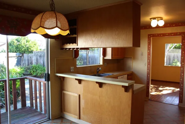 a kitchen with stainless steel appliances a stove a chimney a sink and wooden floor