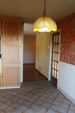 an empty room with wooden floor and entryway