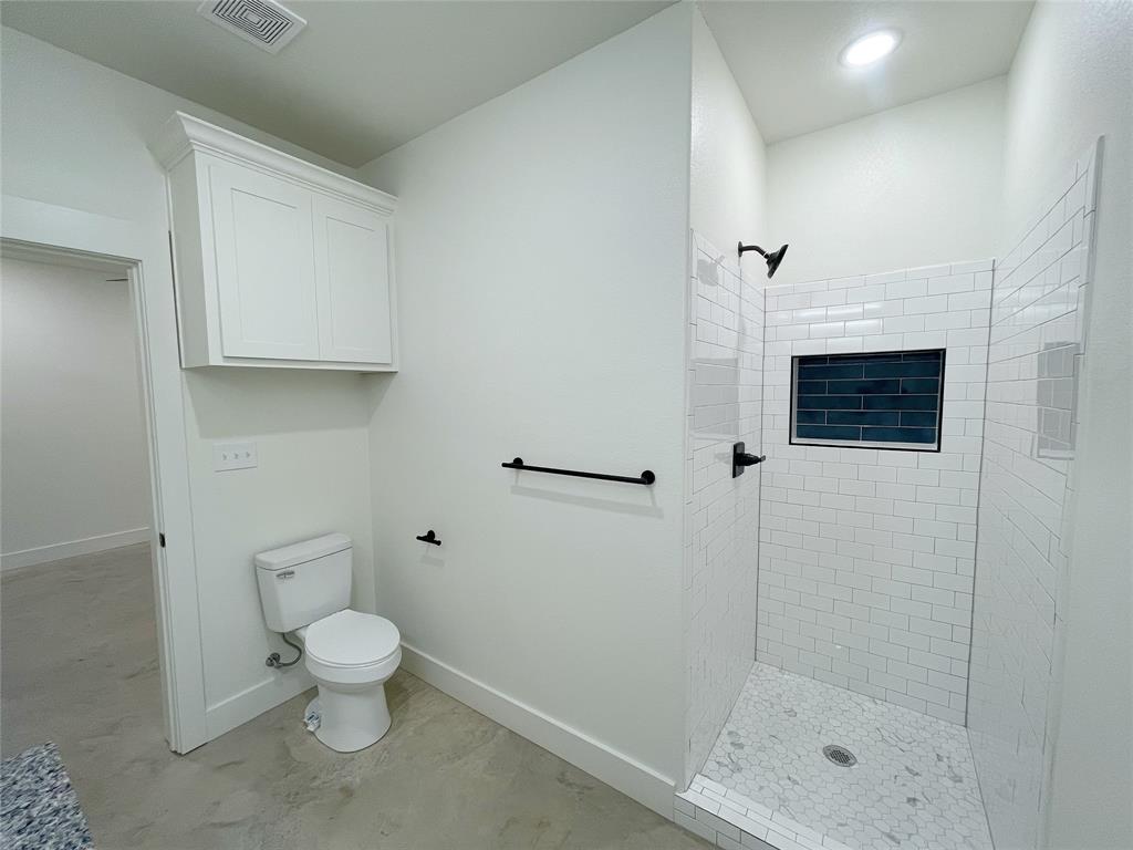 607 West Baker Street Denison, TX 75020 - Photo 11 of 19 Bathroom featuring toilet and a tile shower