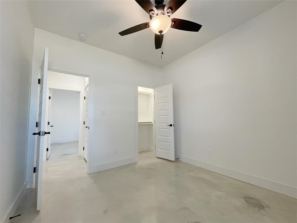 607 West Baker Street Denison, TX 75020 - Photo 12 of 19 Unfurnished bedroom featuring a walk in closet and ceiling fan