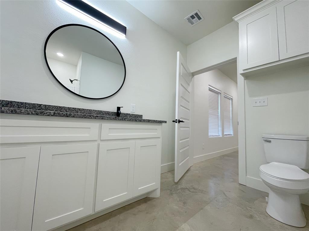 607 West Baker Street Denison, TX 75020 - Photo 10 of 19 Bathroom with vanity, concrete flooring, and toilet