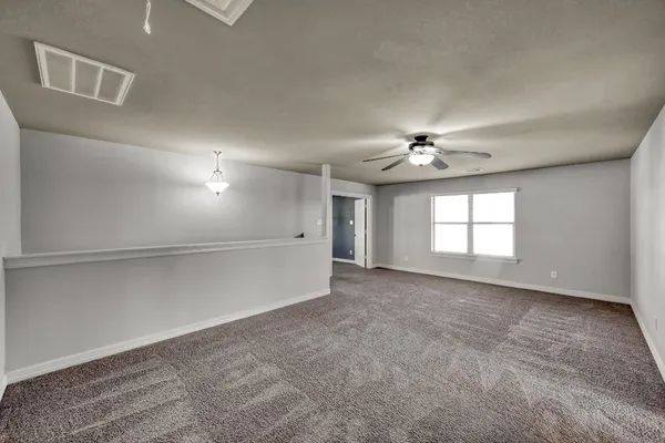 an empty room with fan and windows